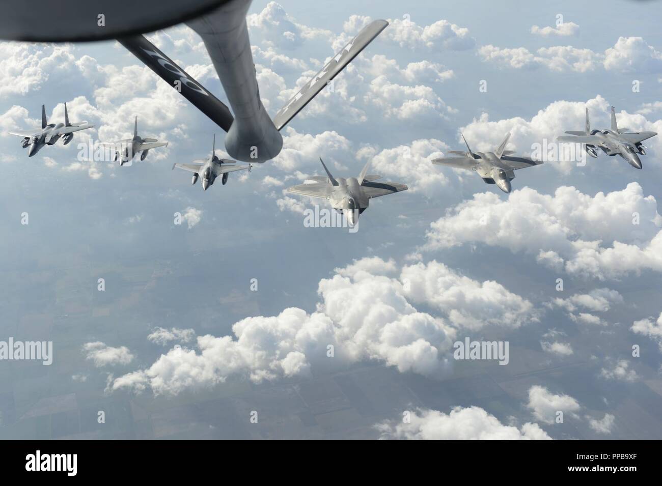 U.S. Air Force F-15C Eagles, F-22 Raptors and Romanian F-16 Fighting Falcons fly in formation above Bucharest, Romania, Aug. 20, 2018. During their deployment to Germany, the F-22s forward deployed to operating locations to assert the U.S. ability to quickly respond and assure allies and partners of U.S. presence in Europe is forward and ready. Stock Photo