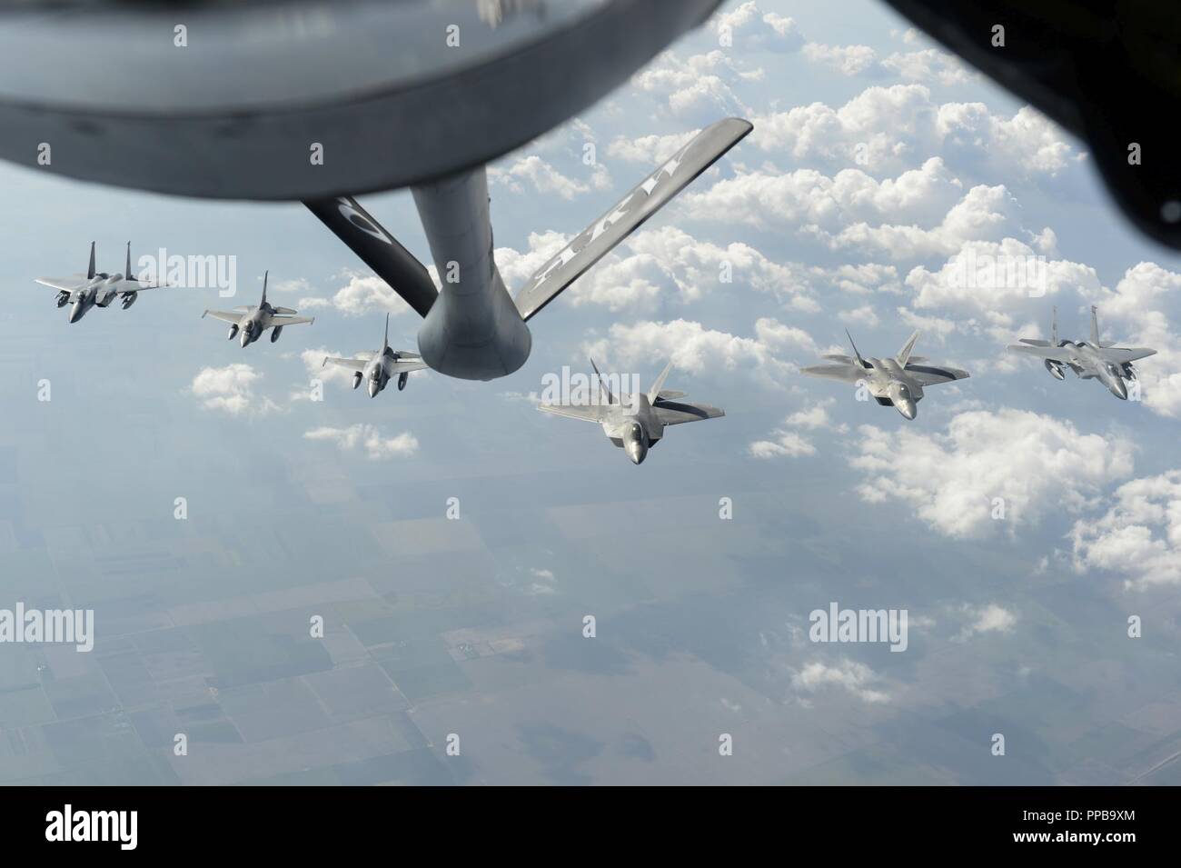 U.S. Air Force F-15C Eagles, F-22 Raptors and Romanian F-16 Fighting Falcons fly in formation above Bucharest, Romania, Aug. 20, 2018. The F-22s deployed from Germany to operating locations within other NATO member nations in order to maximize training opportunities while strengthening the NATO alliance and deterring regional aggression. Stock Photo