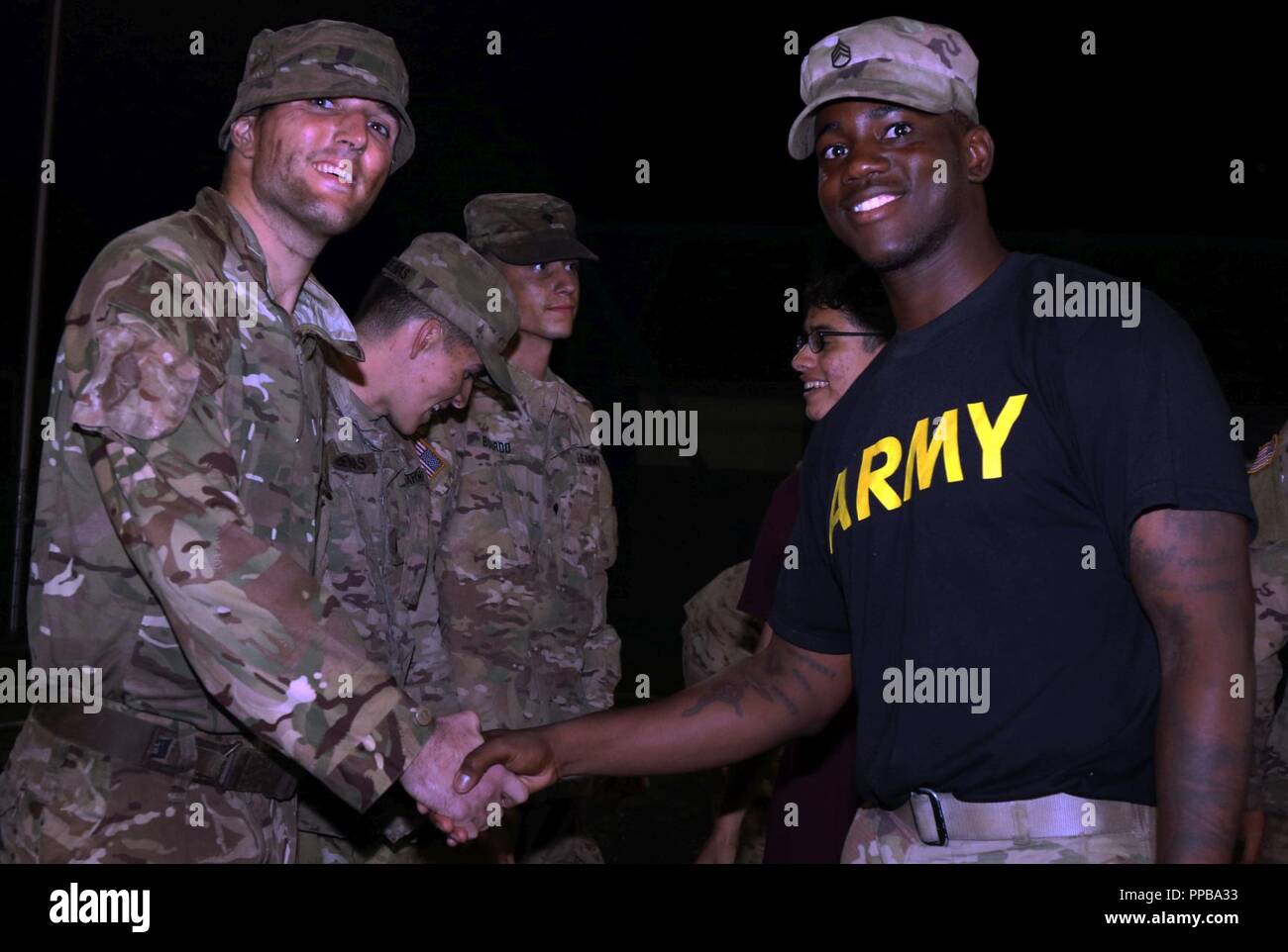 Staff Sgt. Meegal Downer [right], an infantryman with the 1st Squadron, 2nd Cavalry Regiment congratulates U.K. army Lance Cpl. Marcus Rowlands [left] for earning his silver spurs during a spur ride ceremony Aug. 18 at Bemowo Piskie Training Area, Poland. BPTA Soldiers participated in a time-honored cavalry tradition that gave cavalry troops and partner nation participants the opportunity to earn and wear their silver spurs. The Soldiers are on a six-month rotational assignment in support of the multinational battle group comprised of U.S., U.K., Croatian and Romanian Soldiers who serve with t Stock Photo