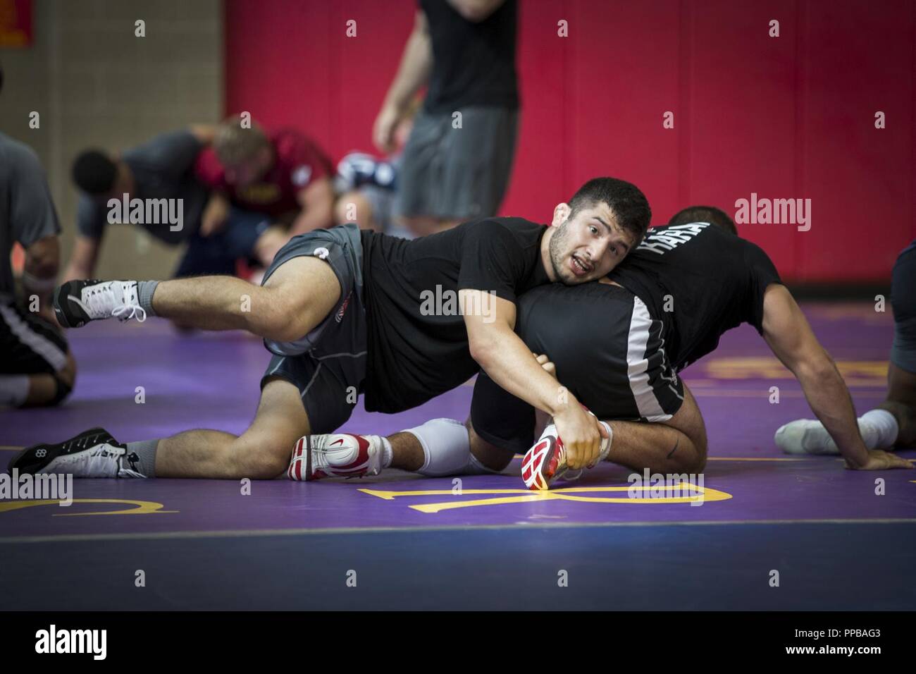 Isaiah Martinez, left, wrestler, USA Wrestling Men’s Freestyle World Team, attempts to subdue his training partner at the 43 Fitness Center at Marine Corps Base Camp Pendleton, California, Aug. 20, 2018. Prior to training the wrestlers warm-up, which included a series of roles, work-outs and stretches, helped them maintain flexibility and avoid potential injuries caused by tight muscles. Stock Photo