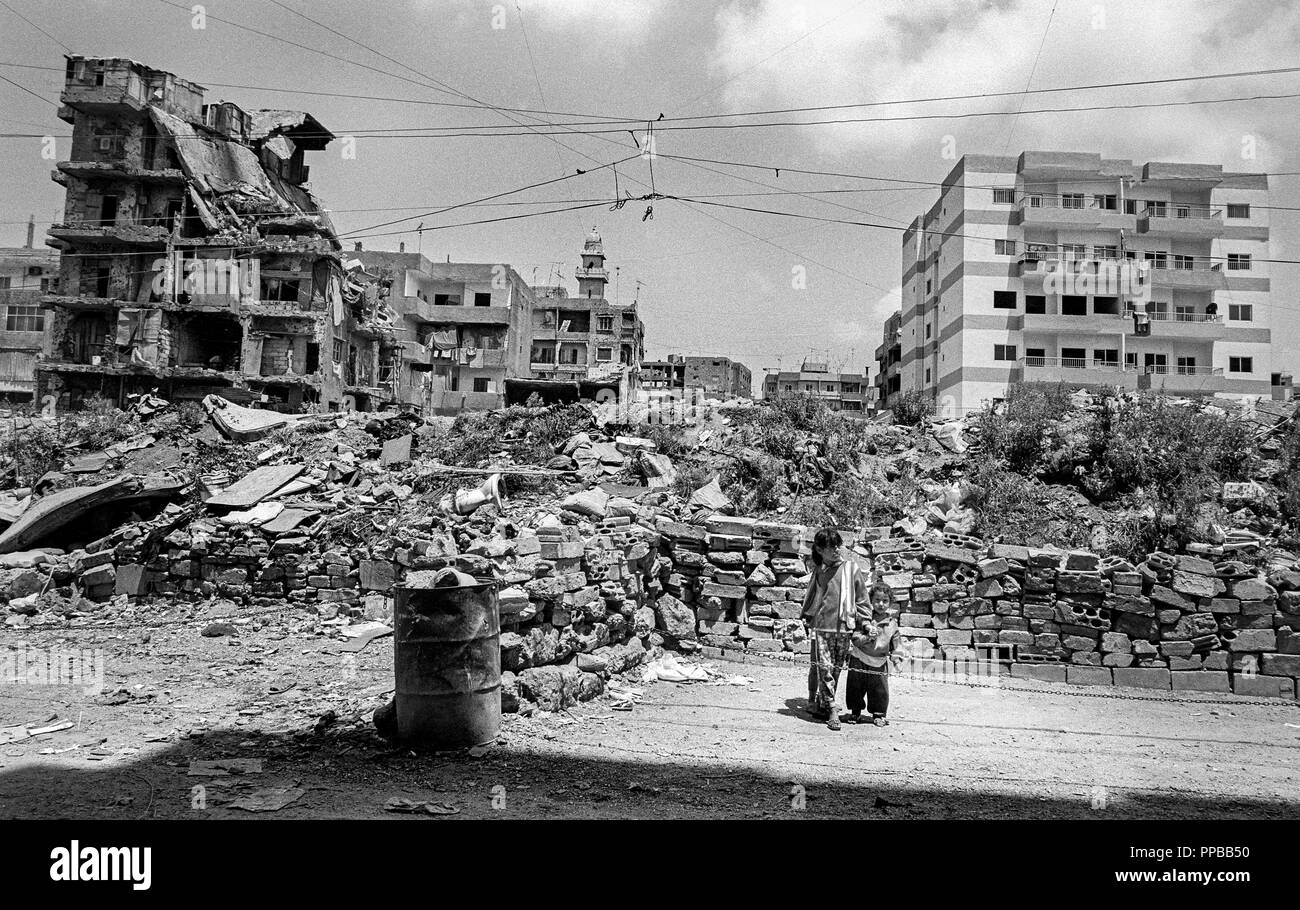 Two children standing near bombed out buildings and new builds. Palestinian Refugee Camps of Sabra and Shatila, Beirut, Lebanon 1998. Stock Photo