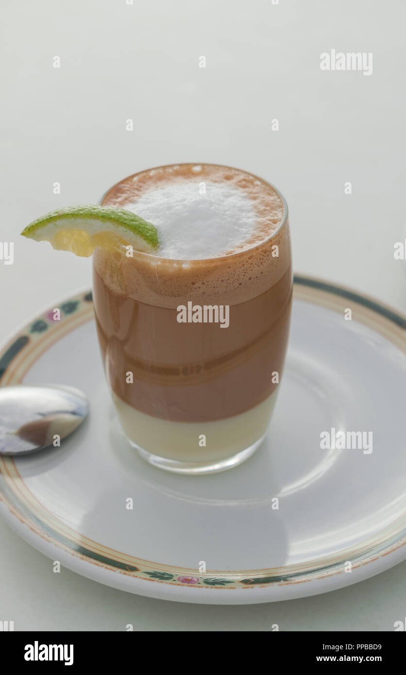 Coffee With Milk Cinnamon Liqueur And Lemon In A Glass On A White Plate With White Table Background Stock Photo Alamy