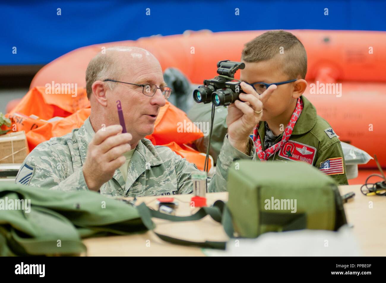 Air Force Master Sgt. Keith Koblitz demonstrates night vision goggles to Honorary Air Force Col. Shane Sagraves while Sagraves toured the 121st Air Refueling Wing during his “Pilot for a Day” activities at Rickenbacker Air National Guard Base in Columbus, Ohio on August 22, 2018. Shane and the rest of his family were hosted by the 121st ARW for “Pilot for a Day”, which gives kids and teens with a chronic or life threatening illness a chance to experience a day in the life of an Air National Guardsman. Shane’s busy day included a tour of the KC-135 Stratotanker, training in the refueling boom s Stock Photo