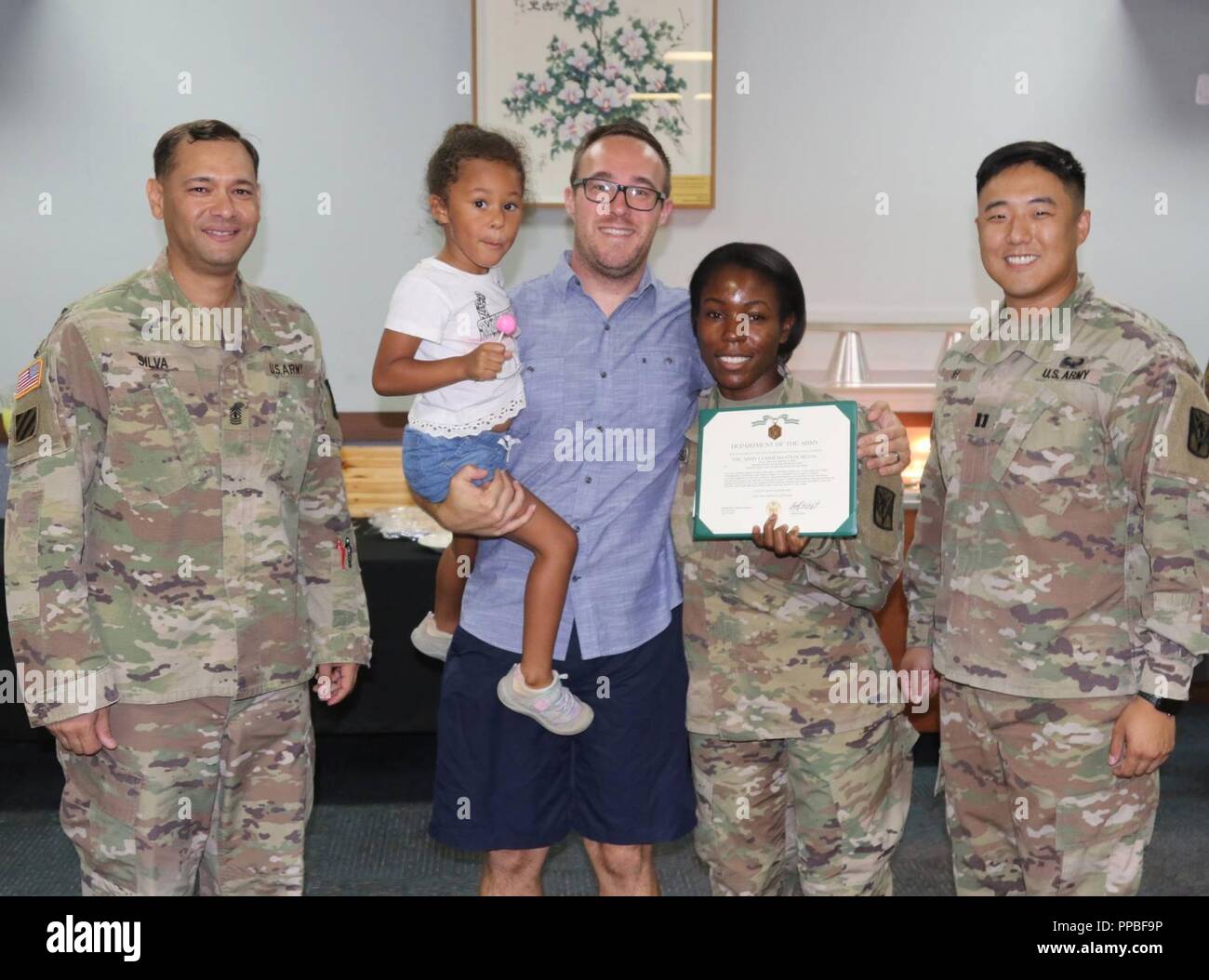 Staff Sgt. Shaniek Tose, flanked by her husband, Daniel Tose, daughter, Isabelle, 3, and her Headquarters, Headquarters Battery, 6-52 Air Defense Artillery Battalion, was recognized during an end-of-tour ceremony, August 20, at Suwon Air Base. During the ceremony, Tose officially announced her decision to enter the Army's Master of Social Work program and become a second lieutenant rather than accept a promotion to sergeant first class, for which she had recently been Department of the Army selected. Stock Photo