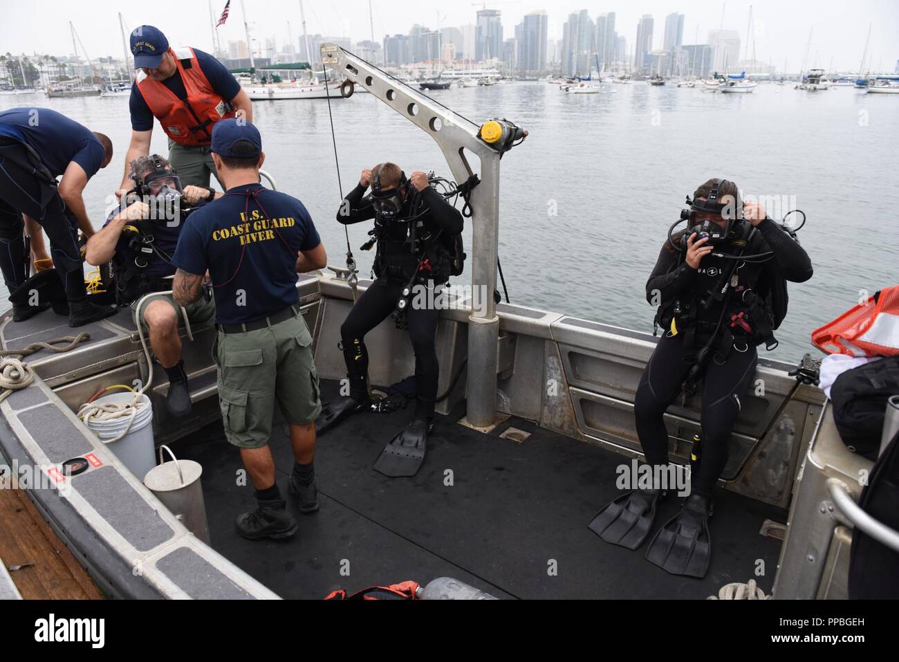Divers from the Coast Guard Regional Dive Locker West, Maritime Security Response Team West, prepare to enter the water along North Harbor Drive, San Diego Aug. 25, 2018. The dive team was participating in Operation Clean Sweep 2018, a community cleanup effort along the San Diego Bay. Stock Photo