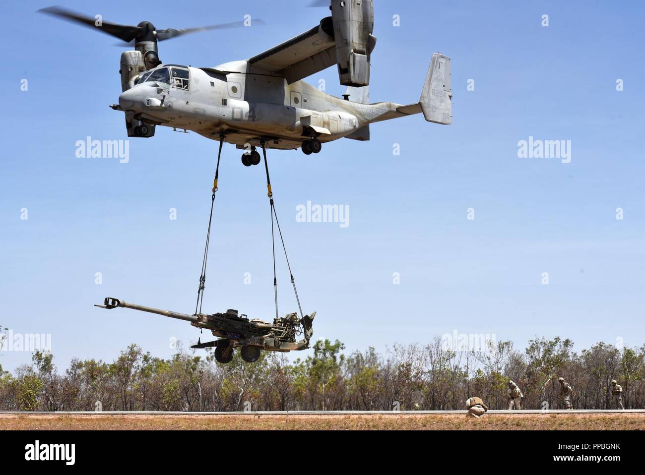 An MV-22 Osprey with Marine Medium Tiltrotor Squadron 268 (VMM-268) airlifts an M777 Howitzer from Mike Battery, 3rd Battalion, 11th Marine Regiment, during Marine Rotational Force – Darwin’s Exercise Koolendong at Mount Bundey Training Area, Australia, Aug. 25, 2018. This is the first time an Osprey has lifted and moved a Howitzer in an austere environment in Australia and it is the first time an entire artillery battery deployed in support of MRF-D. Stock Photo