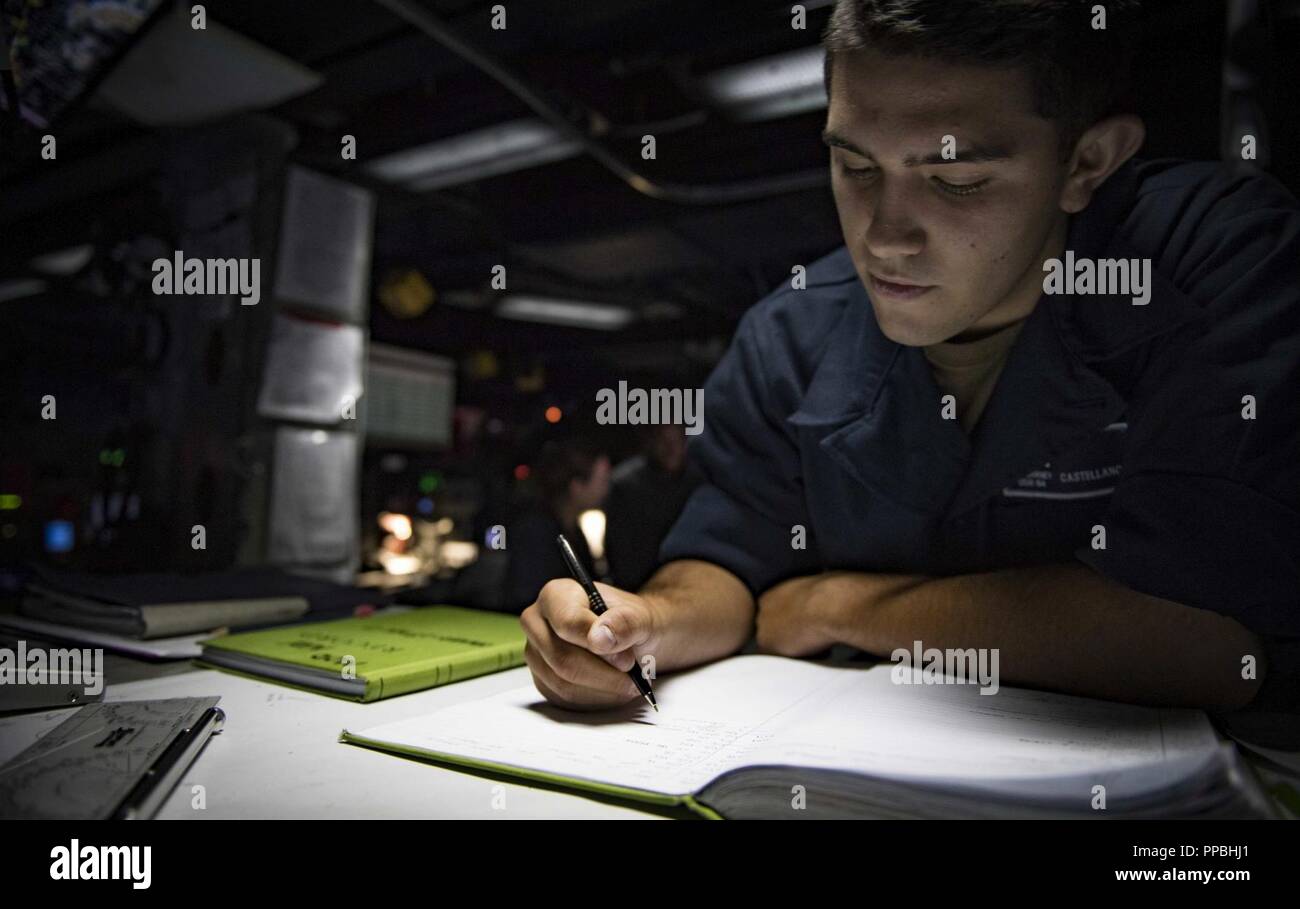 SEA (Aug. 28, 2018) Operations Specialist Seaman Philip Castellanos stands watch in the combat information center aboard the Arleigh Burke-class guided-missile destroyer USS Carney (DDG 64) Aug. 28, 2018. Carney, forward-deployed to Rota, Spain, is on its fifth patrol in the U.S. 6th Fleet area of operations in support of regional allies and partners as well as U.S. national security interests in Europe and Africa. Stock Photo