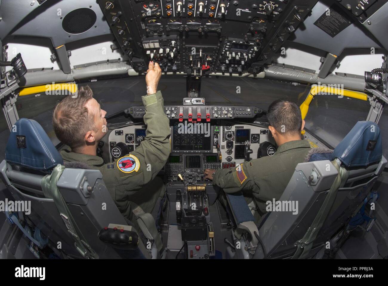 U.S. Air Force Capt. Josh Welch, left, and 2nd Lt. Kent Melendez, right, both pilots assigned to the 50th Air Refueling Squadron, perform pre-flight procedures in the KC-135 flight simulator at MacDill Air Force Base, Fla, Aug. 17, 2018. Pilots perform multiple simulator flights each year testing their proficiency with the aircraft and their ability to handle a wide array of emergency scenarios. Stock Photo