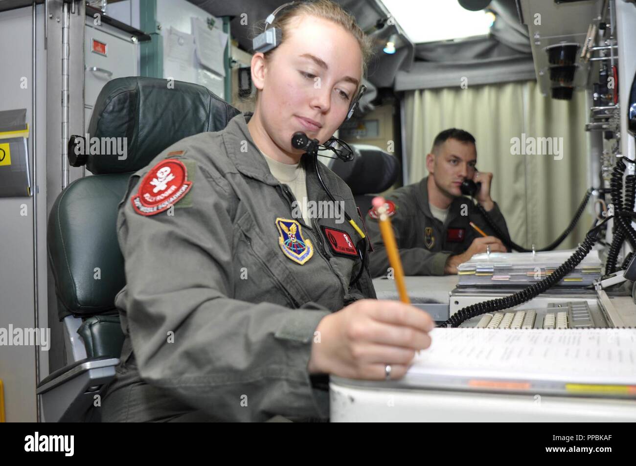 Second Lieutenant Teah Heidorn, 320th Missile Squadron deputy combat crew commander, writes notes during a Simulated Electronic Launch-Minuteman test inside a launch control center at a missile alert facility in the 90th Missile Wing missile complex, Aug. 21, 2018. Accomplishing the SELM validates these claims and increases the deterrent capability of the Minuteman III ICBM weapon system. Stock Photo