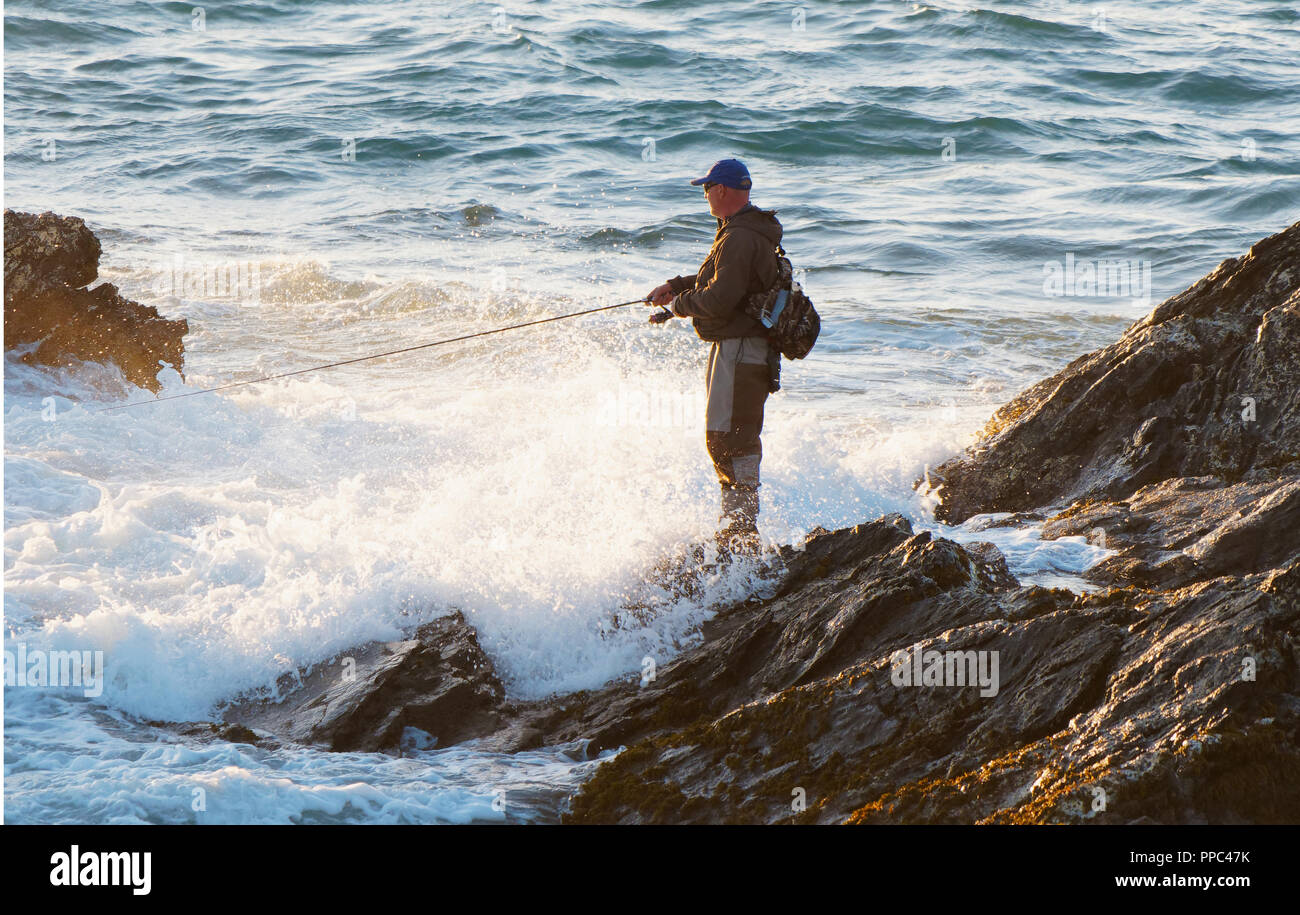 Newquay, Cornwall. 25th Sep 2018. UK Weather, Spring tide sea angler at  Fistral Bay takes fishing to the white knuckle sport category as the high  spring tide surrounds his extreme spot, defying
