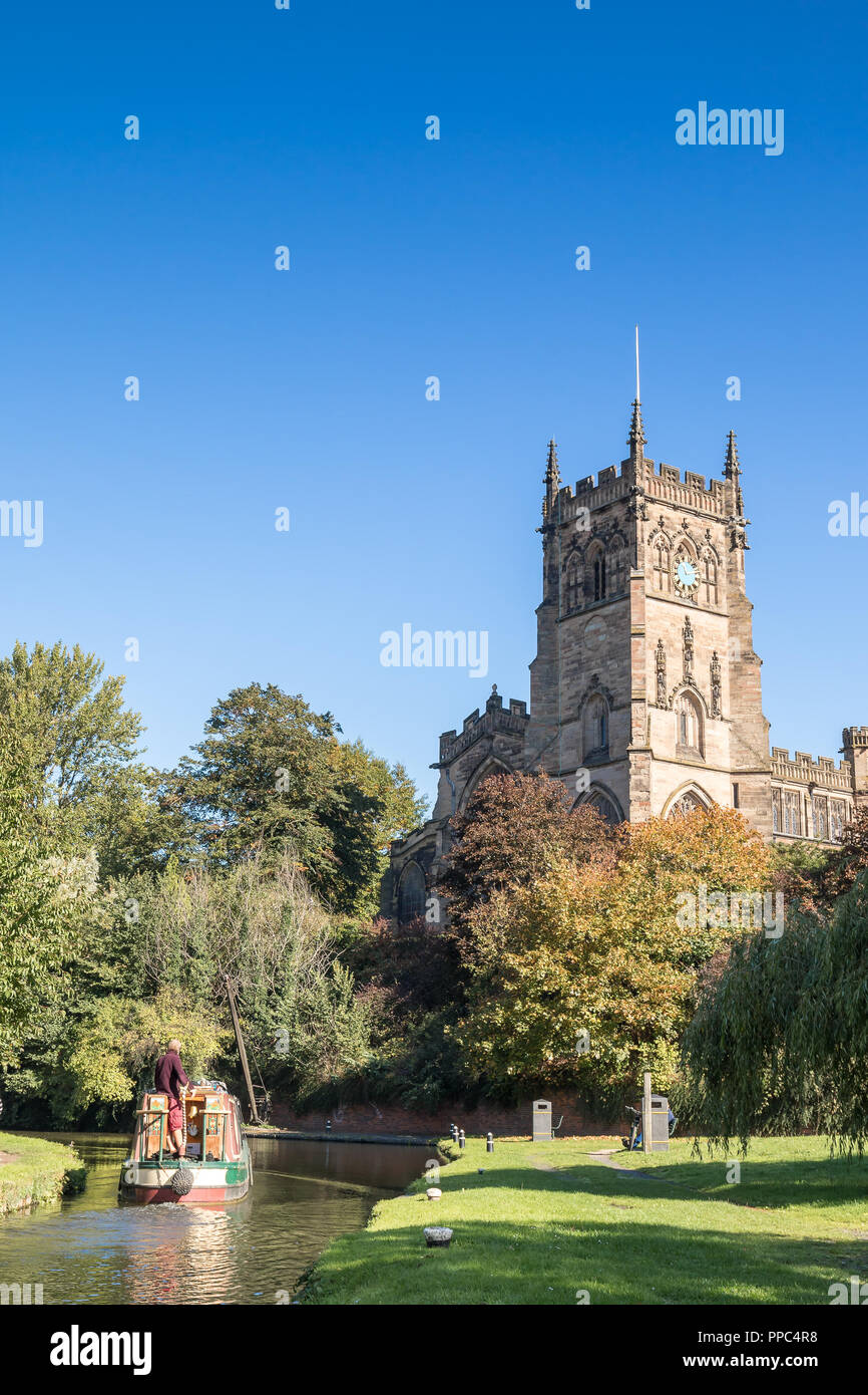 Kidderminster, UK. 25th September, 2018. UK weather: after an unseasonably cold evening and chilly start, the folk of Kidderminster welcome this morning's glorious autumn sunshine which is set to last for the remainder of the day. A British couple can be seen here enjoying their UK staycation on a boating holiday - having successfully navigated their canal narrow boat through the Kidderminster lock by St. Mary's Church. Credit: Lee Hudson/Alamy Live News Stock Photo