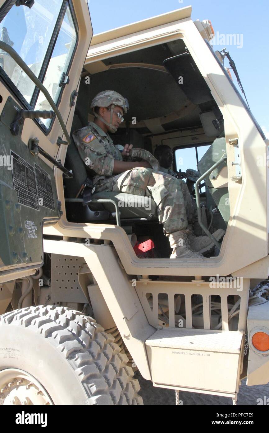 Spc. Michael Brigola (left), a computer detection systems repairer, and Sgt. Jerome Lee (in the driver's seat), a wheeled vehicle mechanic, both of Echo Company, 328th Brigade Support Battalion, 56th Stryker Brigade Combat Team, 28th Infantry Division, Pennsylvania Army National Guard, prepare to ride in a light medium tactical vehicle in a convoy from the National Training Center, Fort Irwin to the railhead in Yermo, California Aug. 19. Brigola relied heavily upon the advice and mentorship he received from Lee during the 56th SBCT combat training rotation at NTC. Stock Photo