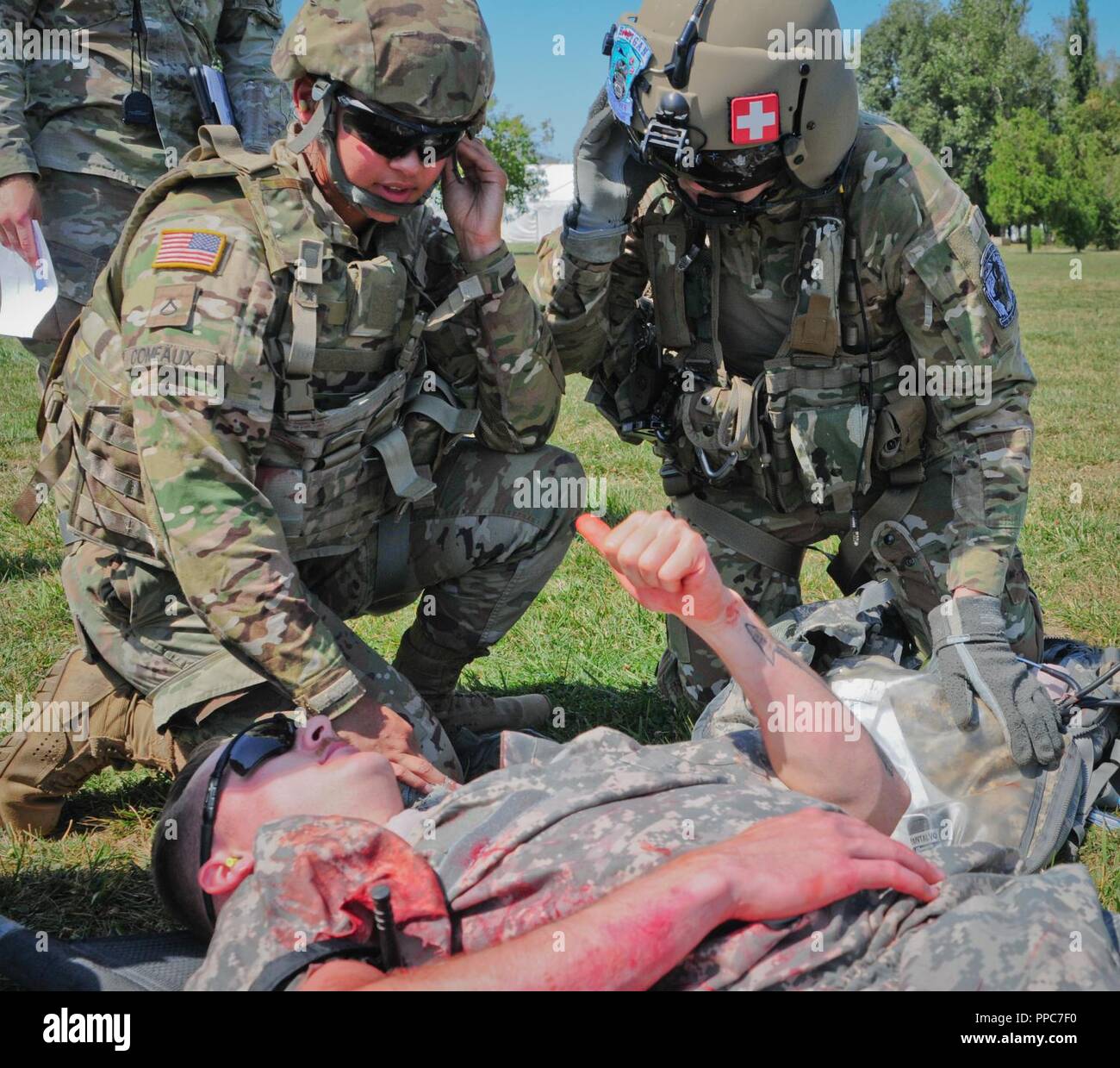 U.S. Army Pfc. Jasmine Comeaux (left) a combat medic assigned to The Headquarters and Headquarters Company, 2nd Battalion 5th Cavalry Regiment, 1st Armored Brigade Combat Team, 1st Cavalry Division explains the simulated casualties injuries to U.S. U.S. Army Sgt. Grayson Harris (right) the medevac flight medic at Mihail Kogalniceanu Air Base in Romania, August 20, 2018. Soldiers conducted Table VIII Medic Skills Validation, an annual training event required for Soldiers to keep their Military Occupational Specialty qualification as a combat medic. Stock Photo