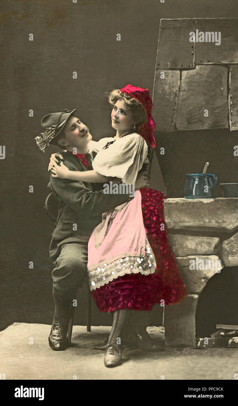 Couples, flirt, man and woman in national costumes hug each other in the kitchen, 1910s, Germany Stock Photo