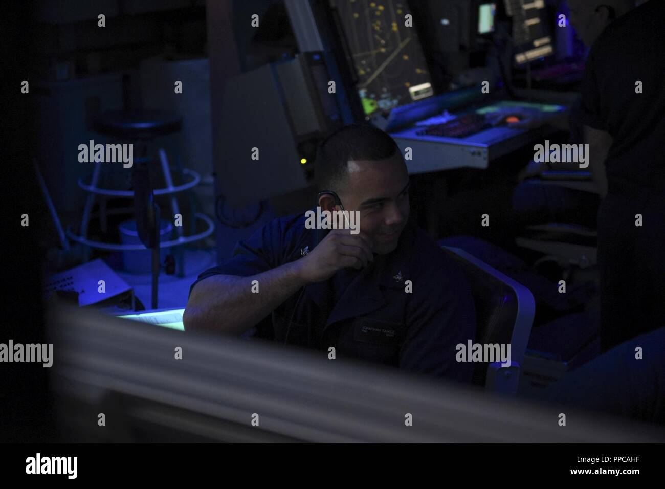 ATLANTIC OCEAN (Aug. 21, 2018) – Air-Traffic Controller 3rd Class Jonathan Tamez performs a communications check while he stands watch in the Carrier Air Traffic Control Center on the Nimitz-class aircraft carrier USS Abraham Lincoln (CVN 72). Abraham Lincoln is currently underway conducting carrier qualifications. Stock Photo