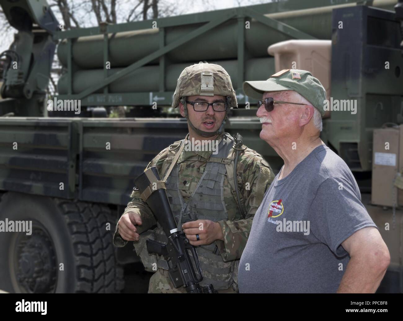 Army Spc. Caulin L. Gagne, a muliti-launch rocket system crewman assigned to the 197th Field Artillery Brigade, answers questions about a weapon system on Aug. 14, 2018 at a traiining site on Camp Grayling, Mich. Peter Dearness, the owner of New England Southern Railroad, visited the 197th FAB during their annual training as part of a tour with the N.H. Employer Support of the Guard and Reserve. ( Stock Photo