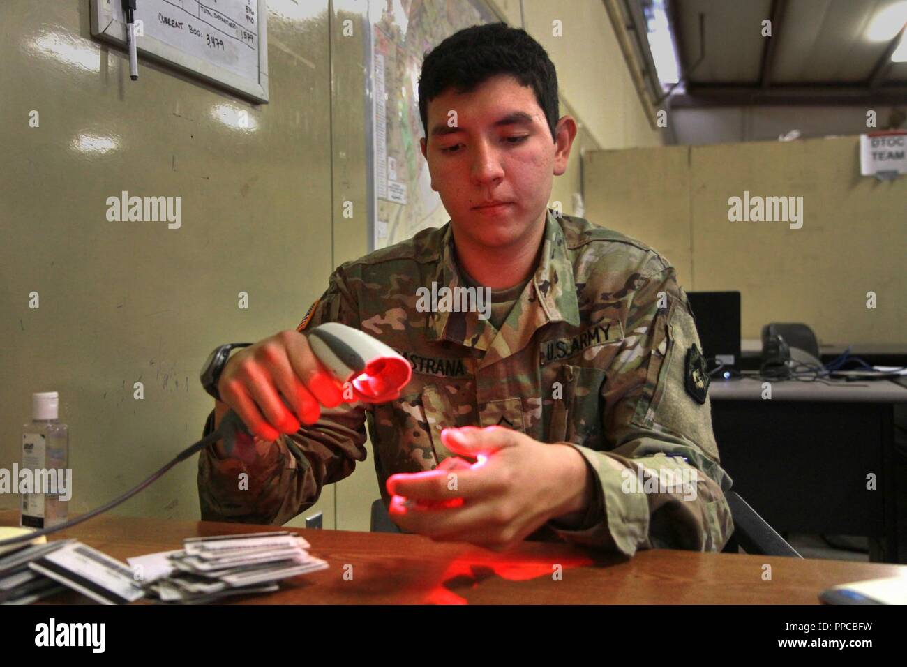 Pvt. Juan Pastrana, a signal support systems specialist with the 213th Personnel Company, 213th Regional Support Group, Pennsylvania Army National Guard scans the military identification cards of 1st Battalion, 110th Infantry Regiment, 56th Stryker Brigade Combat Team, 28th Infantry Division Soldiers as they begin the out-processing procedure at the conclusion of their annual training at the National Training Center, Fort Irwin, California Aug. 23. Stock Photo