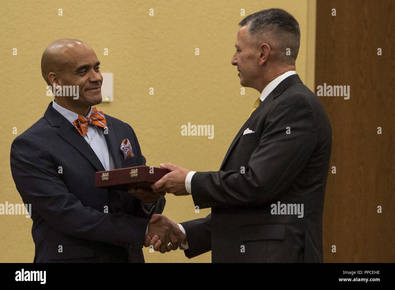 Col. William C. Gray, 6th Marine Corps District commanding officer, presents a gift to Sgt. Maj. Rafael Rodriguez, the Eastern Recruiting Region and Marine Corps Recruit Depot Parris Island sergeant major, during a professional dinner at the 8412 Symposium at Keesler Air Force Base, Mississippi, Aug. 23, 2018. The symposium brought all 6th MCD career recruiters, sergeants major and commanding officers together to provide information, develop updated recruiting products, and conduct sustainment training for the professional development of the recruiting force. Stock Photo