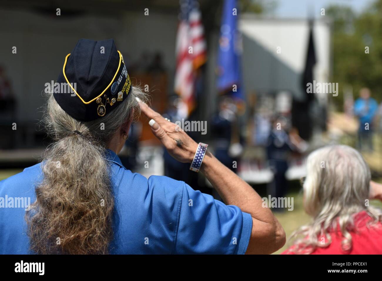 Cynthia Verrill, Linda American Legion Post 807 commander, salutes the flag during the playing of the National Anthem during the Yuba-Sutter Stand Down Aug. 24, 2018, in Marysville, California.The Stand Down gives local veterans and their families the opportunity to seek services, such as dental, veteran benifits and social security, in a sigle location. Stock Photo