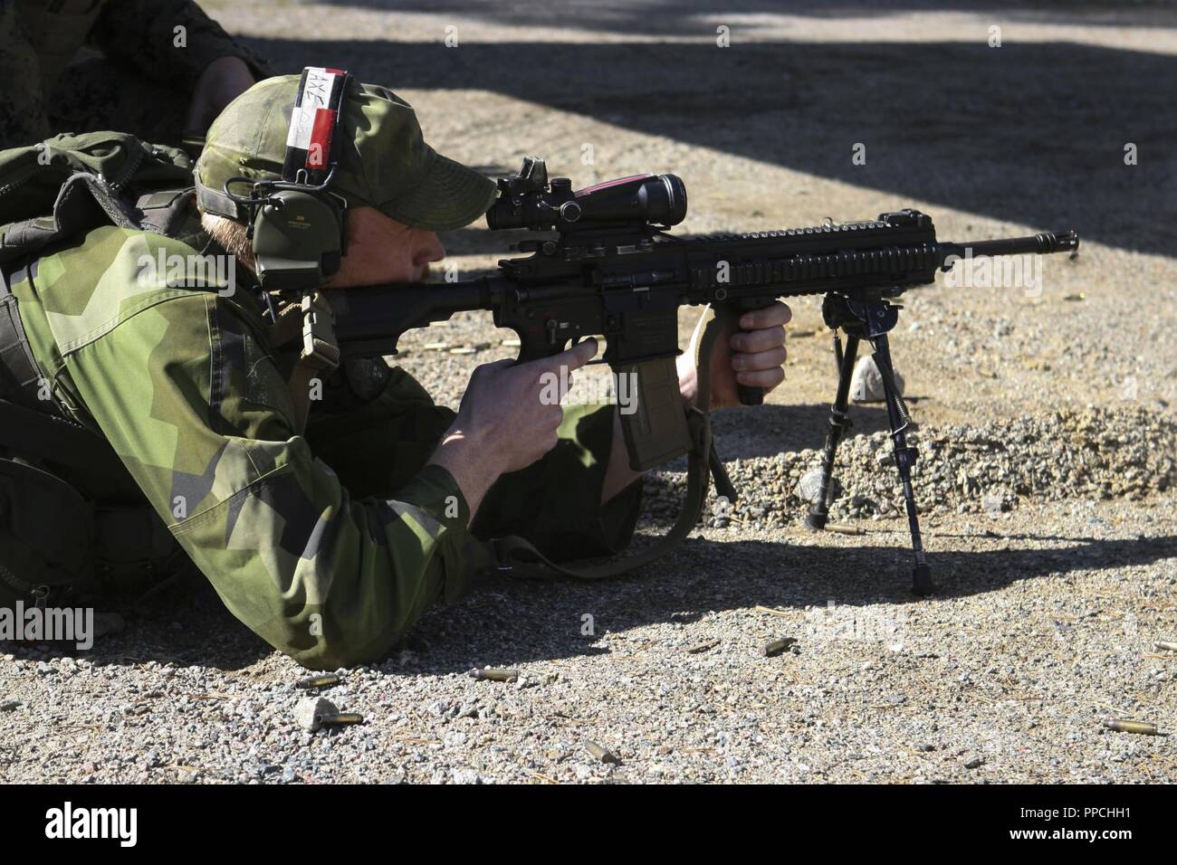 A Swedish Coastal Ranger with 1st Marine Regiment shoots the Marine Corps M27 Infantry Automatic Rifle during the cross-training range at Exercise Archipelago Endeavor aboard Berga Naval Base, Harsfjarden, Sweden, Aug. 22, 2018. Exercise Archipelago Endeavor is an integrated field training exercise that increases operational capability and enhances strategic cooperation between the U.S. Marines and Swedish forces. Stock Photo
