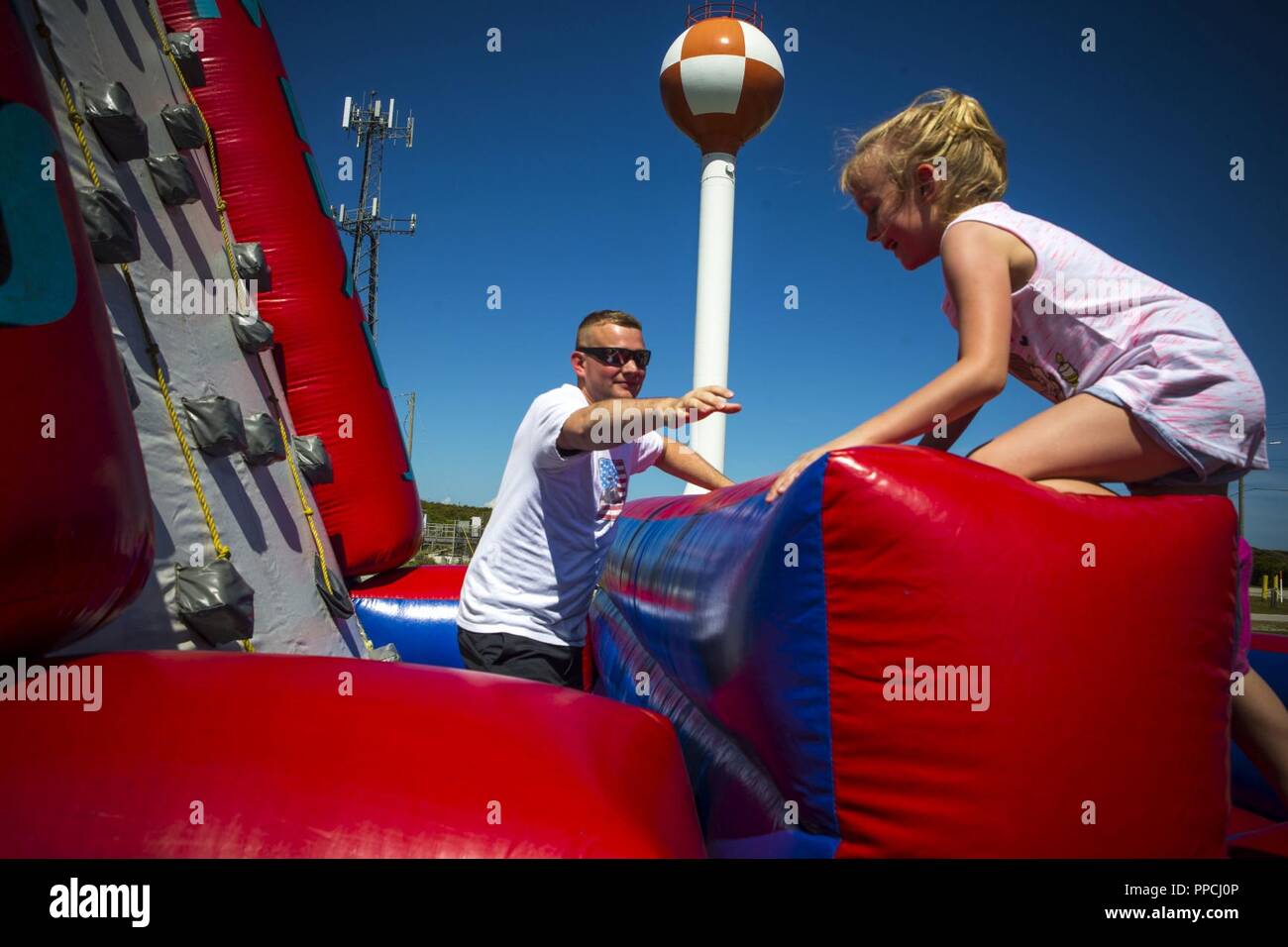 CAMP LEJEUNE, N.C. (August 29, 2018) U.S. Marine Corps Gunnery Sgt. Brian Price, an administrative chief  assigned to the 26th Marine Expeditionary Unit (MEU) plays with his daughter, Haley, during a family fun-day at Onslow Beach, N.C., August 29, 2018. The Marines, Sailors and family members attended the event to celebrate the return of the unit from a recent deployment at sea. Stock Photo