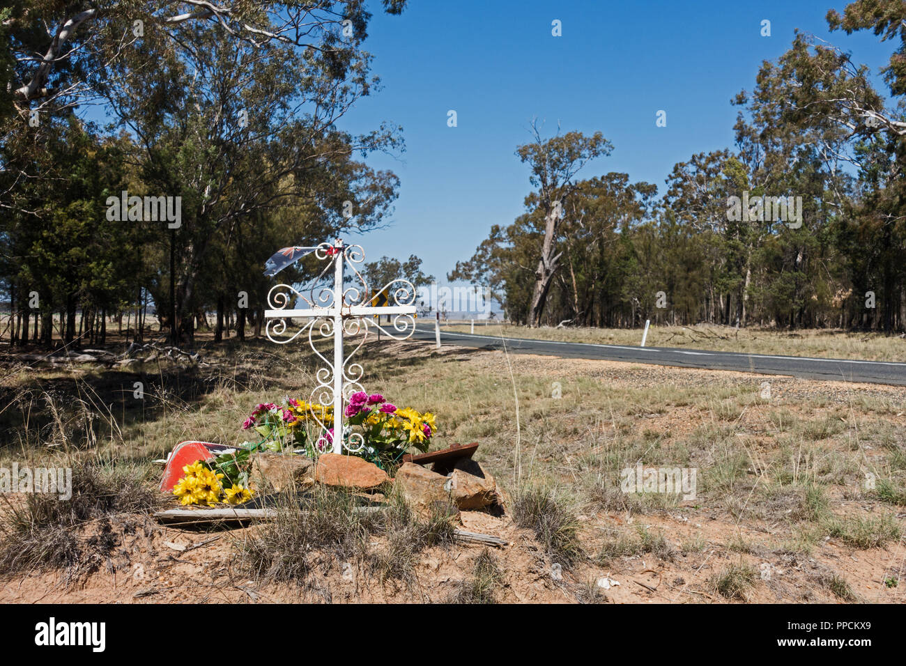 Roadside memorial for accident victim featuring an elaborate Christian Cross and Flowers. Rural NSW Australia. Stock Photo