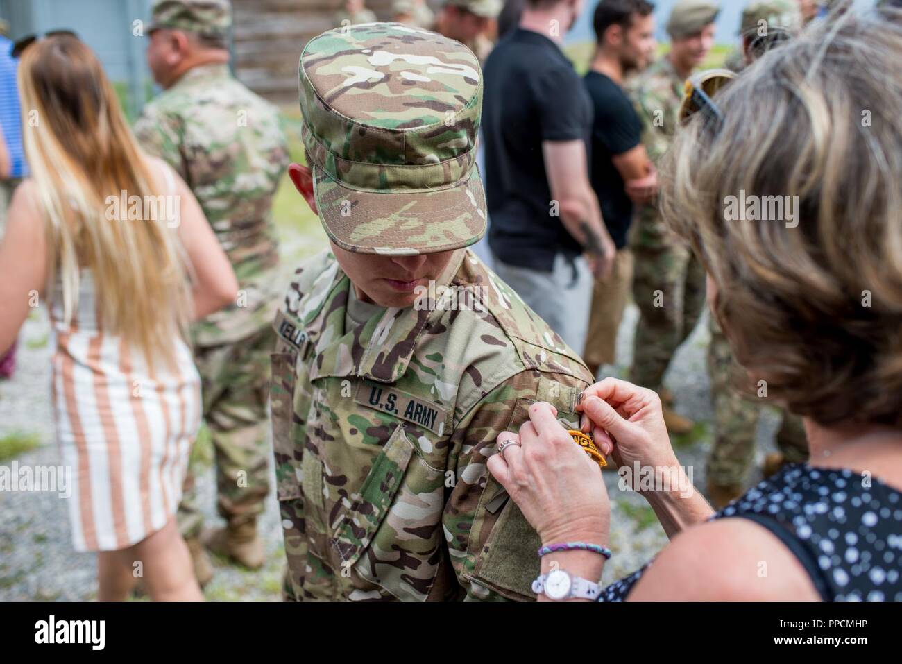 180831-A-YH902-002 (Aug. 31, 2018) Staff Sgt. Amanda F. Kelley, assigned to the 1st Armored Division’s combat aviation brigade at Fort Bliss, Texas, gets her Ranger tab pinned on by a family member during her Ranger School graduation at Fort Benning, Georgia, Aug. 31, 2018. Kelley is the first enlisted woman to earn the Ranger tab. Stock Photo