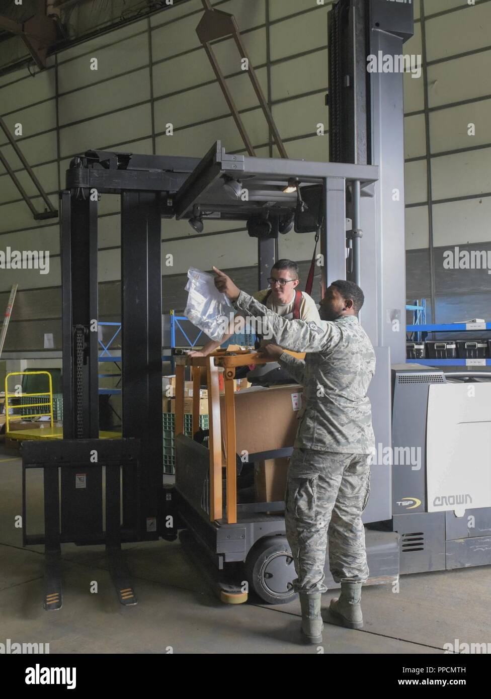 U.S. Air Force Airman 1st Class Hayden Theel, 100th Logistics Readiness Squadron aircraft parts store journeyman, and Staff Sgt. Elijah Rasheed, 100th LRS APS supervisor, locate an aircraft part to be placed in the proper location in a warehouse at RAF Mildenhall, England, Sept. 4, 2018. With all of the energy and time ‘DJ Messiah’, also known as Staff Sgt. Rasheed, puts into his part-time job as a disc jockey, he never lets it interfere with him being a full-time non-commissioned officer. Stock Photo