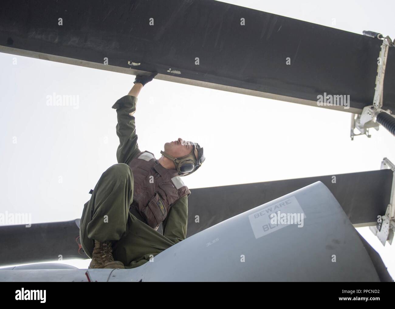 INDIAN OCEAN (Aug. 20, 2018) Marine Corps Cpl. Matthew Regan, from Tampa, Fla., assigned to the Marine Light Attack Helicopter detachment of Marine Medium Tiltrotor Squadron (VMM) 166, performs a pre-flight inspection on a UH-1Y Venom helicopter from the flight deck of San Antonio-class amphibious transport dock USS Anchorage (LPD 23) during a regularly scheduled deployment of the Essex Amphibious Ready Group (ARG) and 13th Marine Expeditionary Unit (MEU). The Essex ARG/13th MEU is a capable and lethal Navy-Marine Corps team deployed to the 7th fleet area of operations to support regional stab Stock Photo