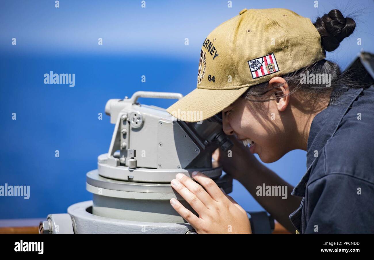 SEA (Aug. 29, 2018) Ensign Karyn Lee uses a telescopic alidade aboard the Arleigh Burke-class guided-missile destroyer USS Carney (DDG 64) Aug. 29, 2018. Carney, forward-deployed to Rota, Spain, is on its fifth patrol in the U.S. 6th Fleet area of operations in support of regional allies and partners as well as U.S. national security interests in Europe and Africa. Stock Photo