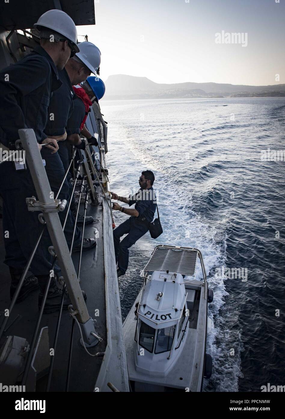 BAY, Greece (Sept. 2, 2018) A harbor pilot boards the Arleigh Burke-class guided-missile destroyer USS Carney (DDG 64) as the ship arrives in Souda Bay, Greece, Sept. 2, 2018. Carney, forward-deployed to Rota, Spain, is on its fifth patrol in the U.S. 6th Fleet area of operations in support of regional allies and partners as well as U.S. national security interests in Europe and Africa. Stock Photo