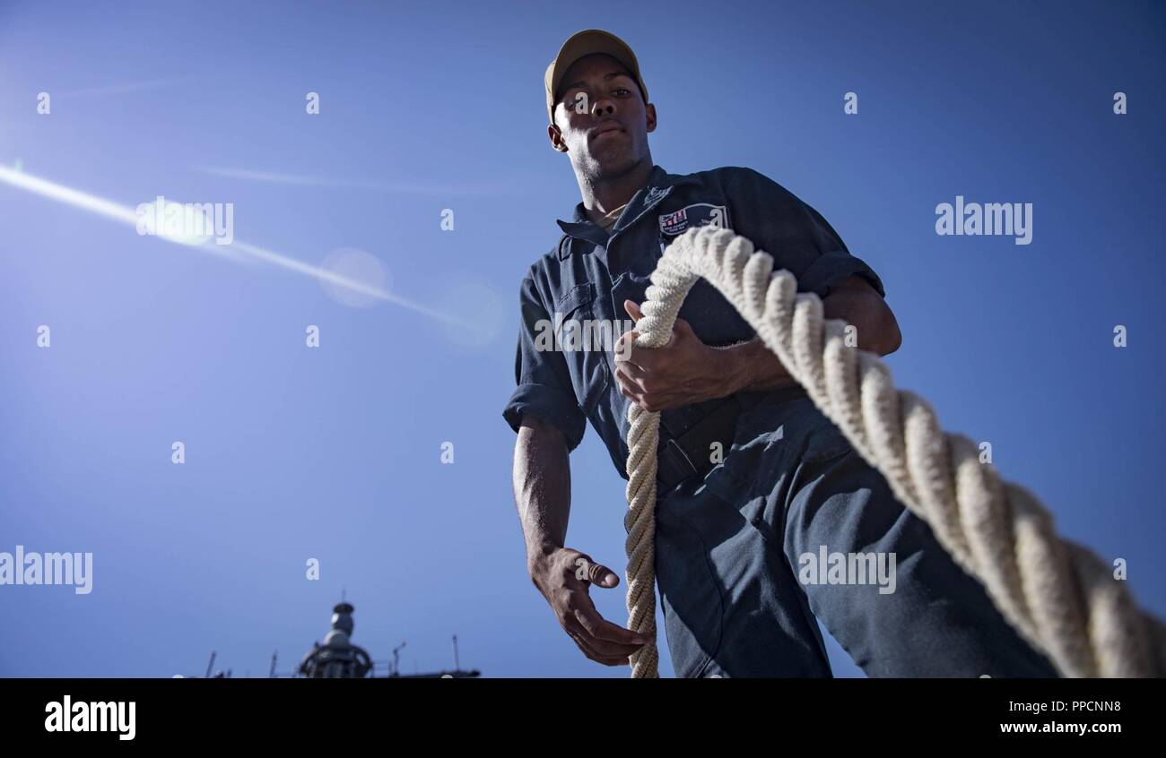 BAY, Greece (Sept. 2, 2018) Seaman Zachary Simon stores mooring line aboard the Arleigh Burke-class guided-missile destroyer USS Carney (DDG 64) as the ship departs Souda Bay, Greece, Sept. 2, 2018. Carney, forward-deployed to Rota, Spain, is on its fifth patrol in the U.S. 6th Fleet area of operations in support of regional allies and partners as well as U.S. national security interests in Europe and Africa. Stock Photo