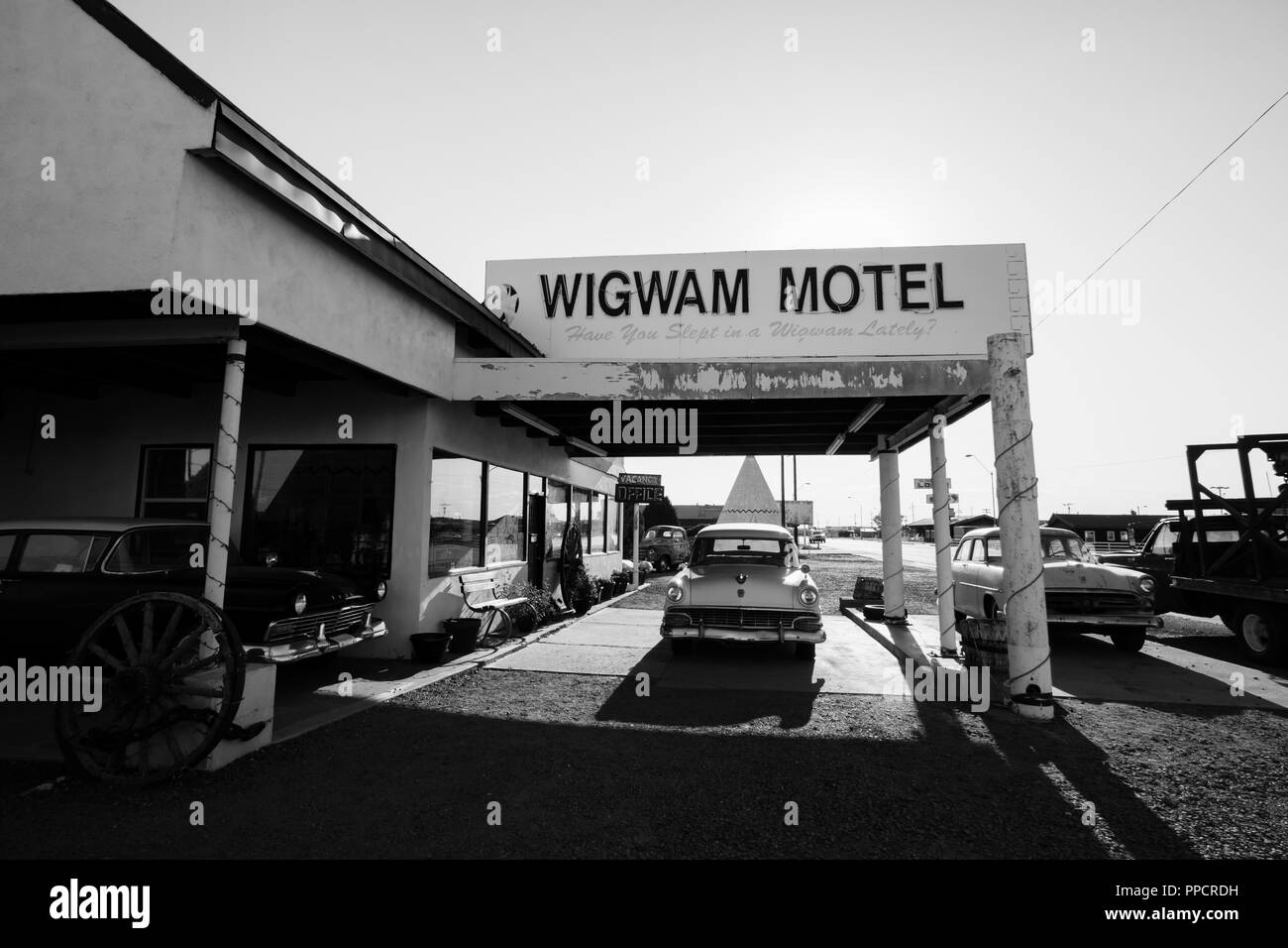 The famous Route 66 landmark - the Wigwam Motel offers hotel guests to sleep in a concrete wigwam structure. Vintage cars add to the nostalgic charm. Stock Photo