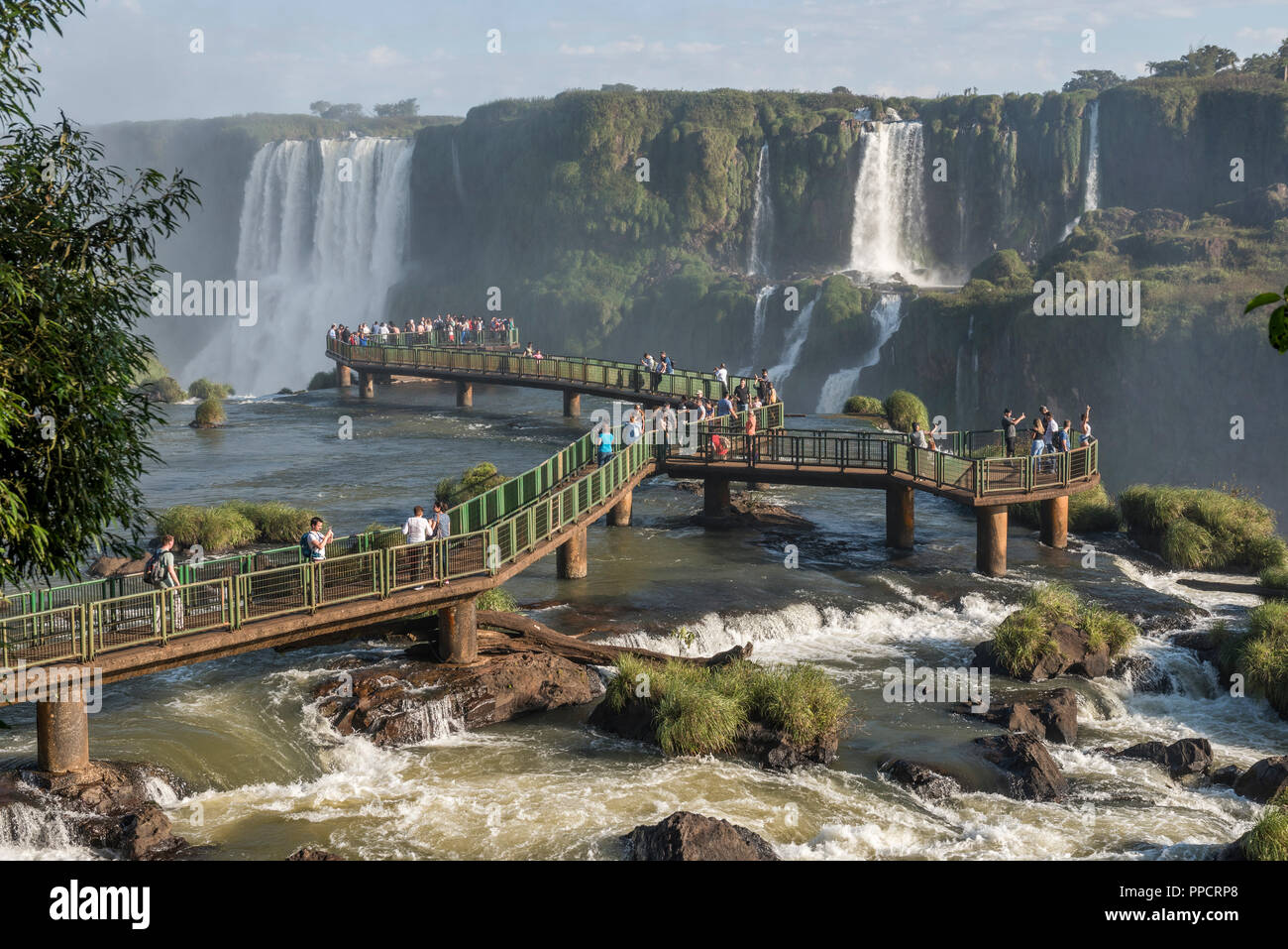 Large group of tourists on bridge enjoying beautiful landscape of Iguazu Falls, Parana, Brazil Stock Photo