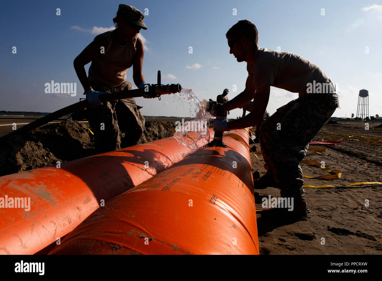 National Guard assembling containment boom to protect Grand Isle State Park beach from oil spill, Grand Isle, Louisiana, USA Stock Photo