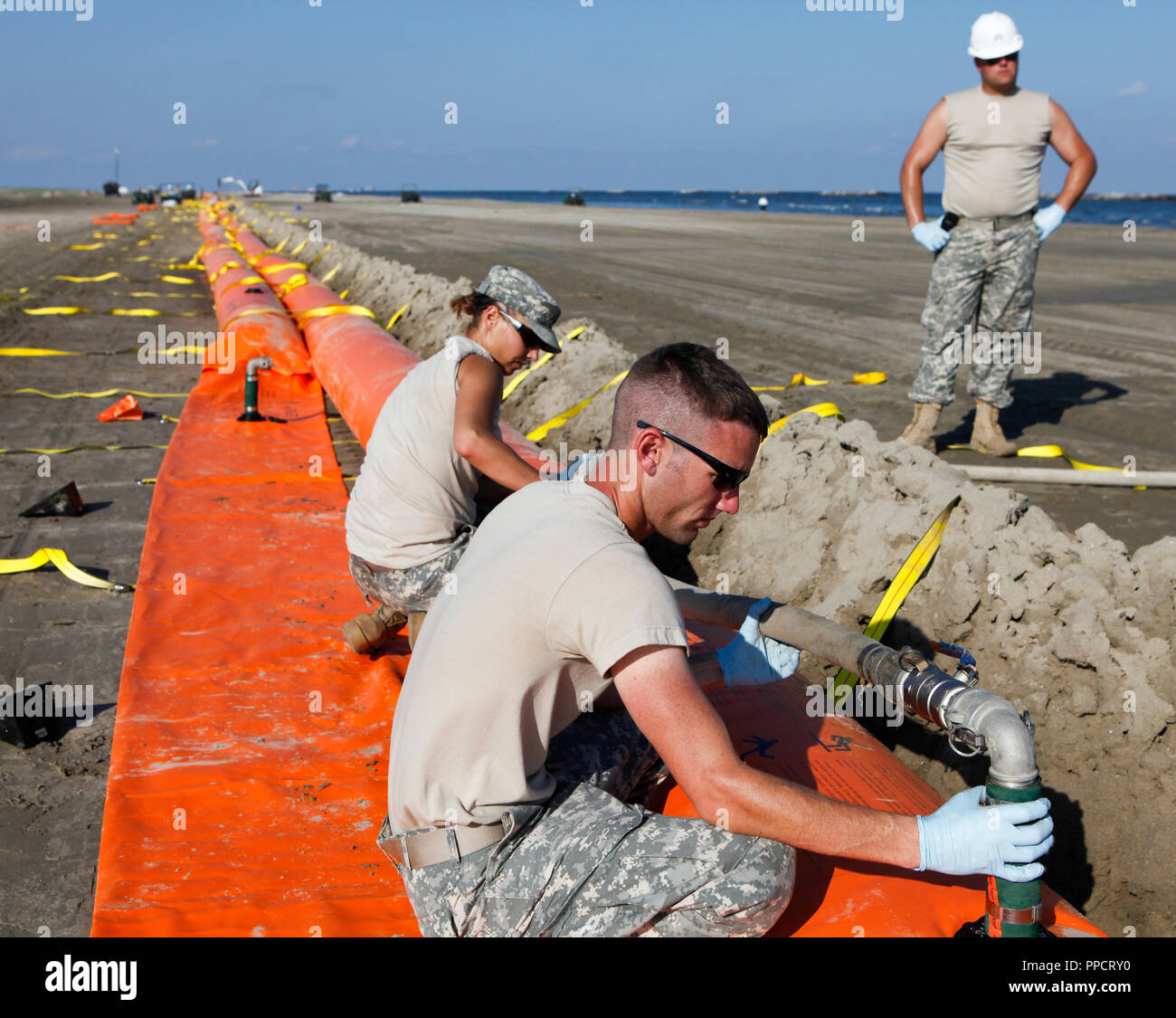 National Guard assembling containment boom to protect Grand Isle State Park beach from oil spill, Grand Isle, Louisiana, USA Stock Photo