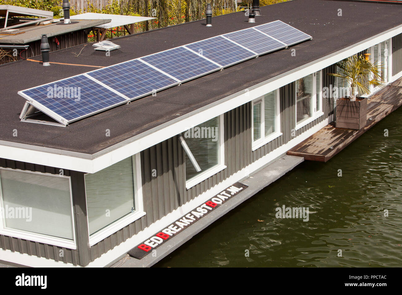 A floating house bed and breakfast with solar panels in Amsterdam, Netherlands. Stock Photo