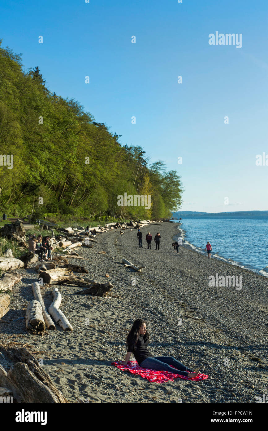 People walking and sitting on coastal beach, Seattle, Washington, USA Stock Photo