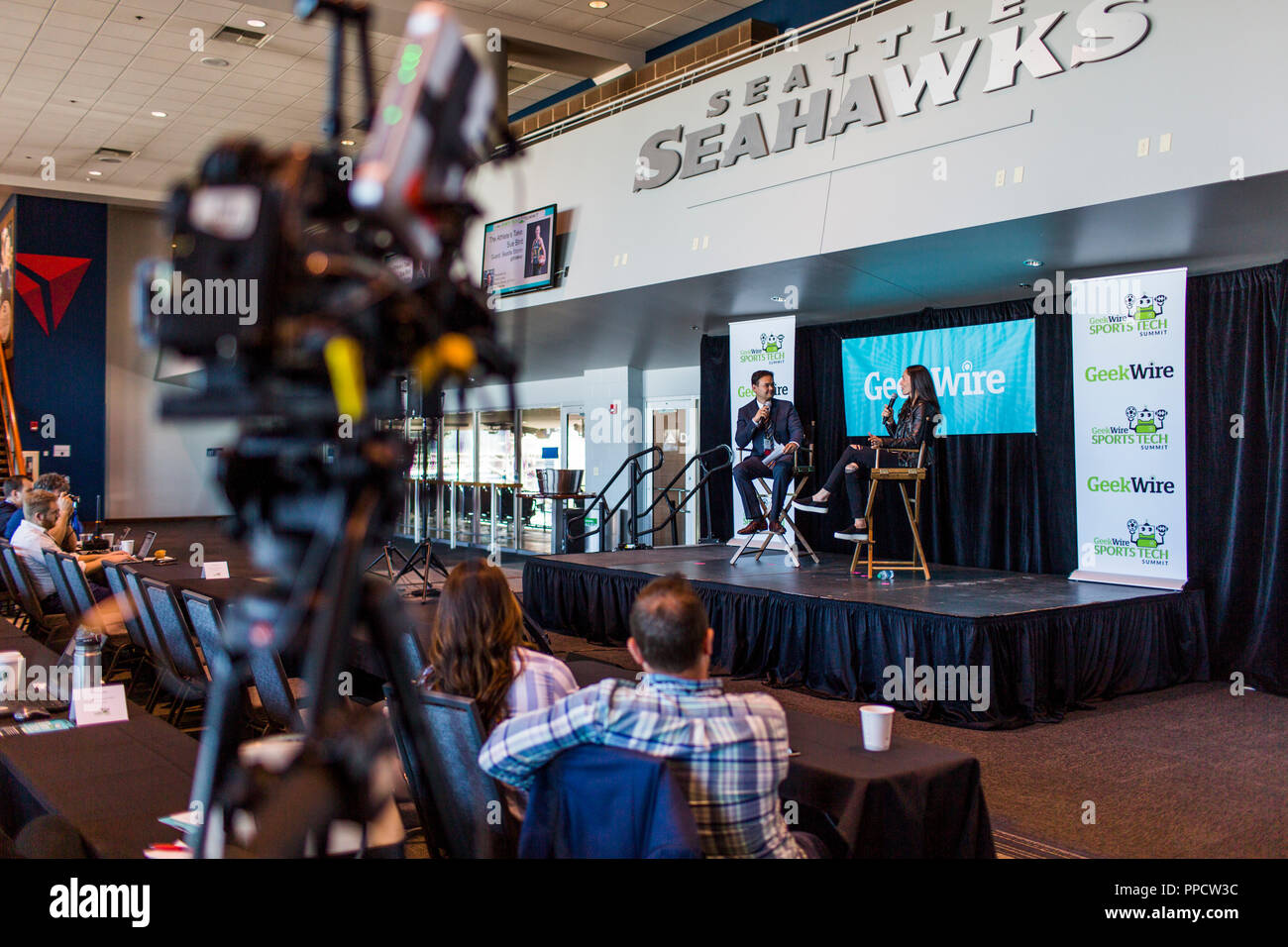 Male journalist interviewing female athlete on stage, Seattle, Washington, USA Stock Photo