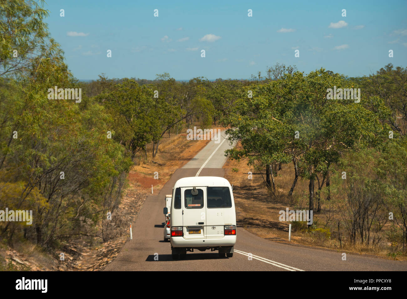 White camper bus driving in the forest of the litchfield national park, Australia Stock Photo