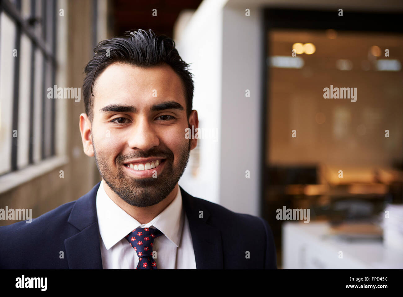 Young Hispanic businessman smiling to camera Stock Photo