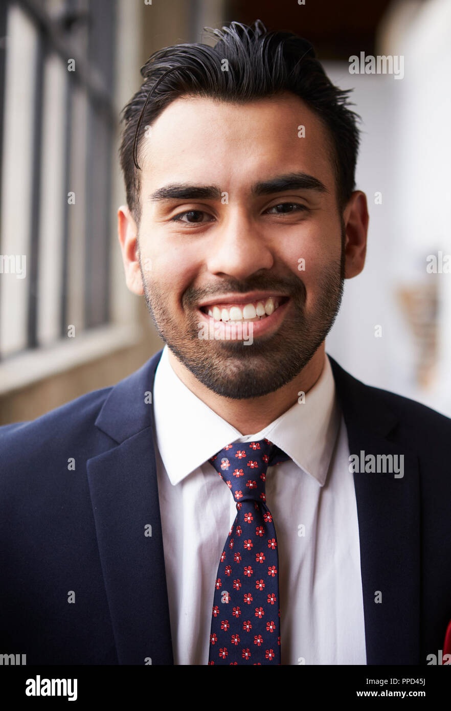 Young Hispanic businessman smiling to camera, vertical Stock Photo