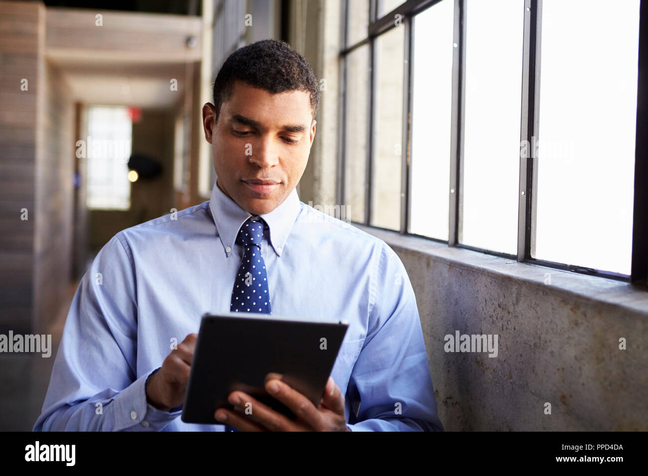 Mixed race businessman using tablet computer Stock Photo