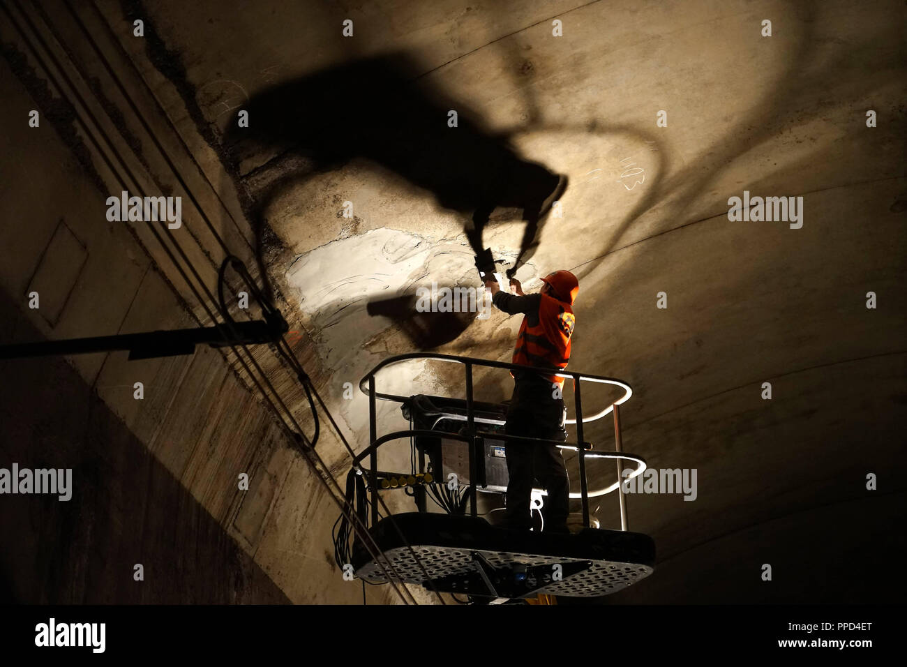 During the nighttime inspection experts of the Munich S-Bahn tunnel look for attrition and damage and mend broken bodies. The photo shows an employee of a construction company repairing a damaged area in the tunnel under the Marienplatz. Stock Photo