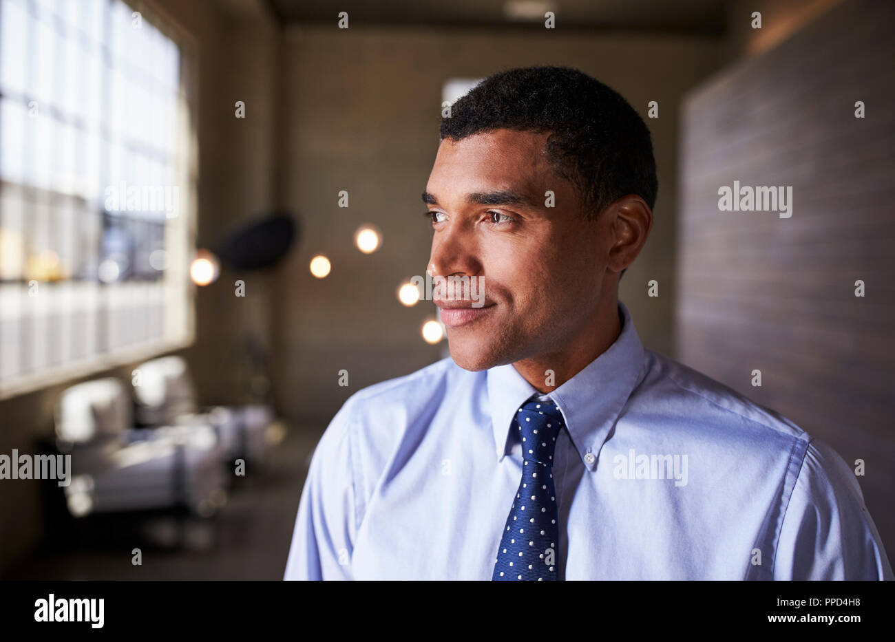 Mixed race businessman looking away smiling, close up Stock Photo