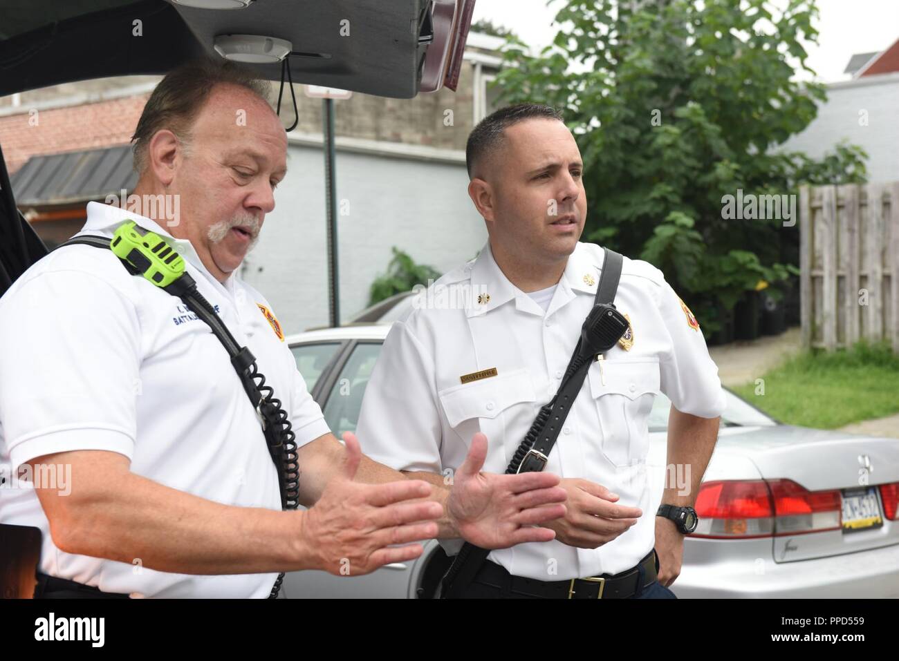 Scott Little, right, fire chief of Lancaster’s Bureau of Fire, gets briefed on the scene of a gas leak by the on-scene battalion chief Aug. 21, 2018, Lancaster, Pennsylvania. A pipe was struck during road work that created a gas leak, which resulted the road being closed off for hours until it was under control. Stock Photo