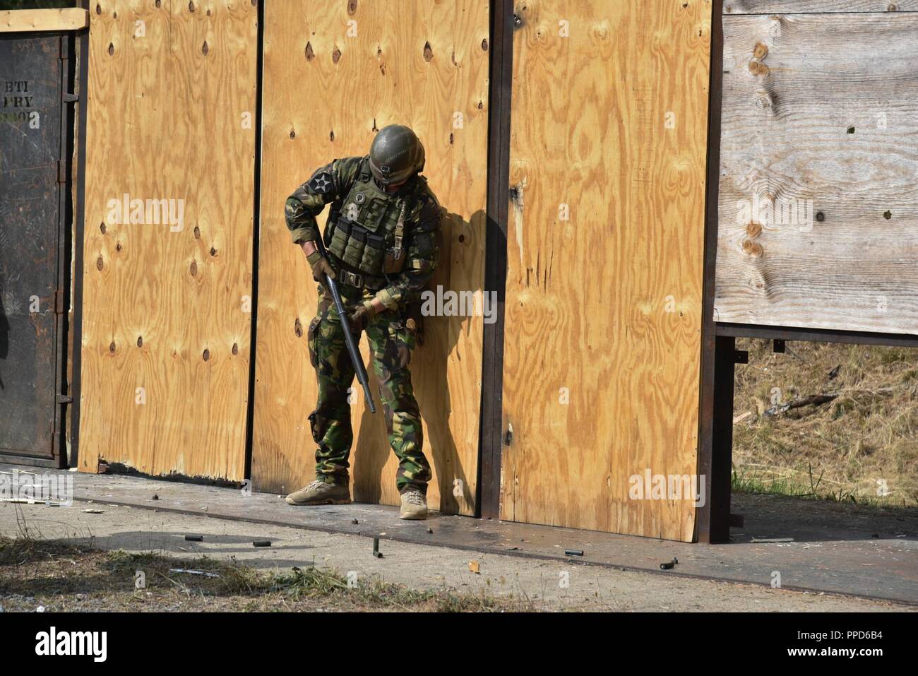 A Dutch Soldier uses an M500 shotgun to breach a door during the Urban Breach Training  at the Grafenwoehr Training Area, Germany, Aug. 29. 2018. U.S. Soldiers assigned to the 7th Army Combined Arms Training Center (CATC), 7th Army Training Command, instructed U.S. Soldiers assigned to various units across Europe, Latvian soldiers and Dutch soldiers on how to conduct urban breaching and offered new techniques for entering hostile or unknown buildings. Stock Photo