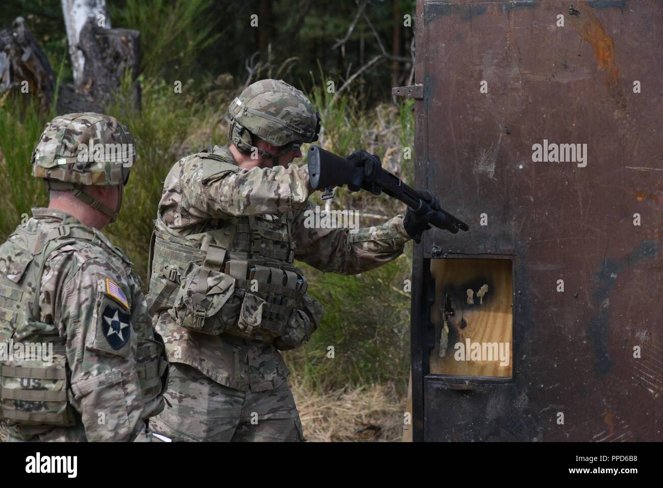 A Dutch Soldier uses an M500 shotgun to breach a door during the Urban Breach Training  at the Grafenwoehr Training Area, Germany, Aug. 29. 2018. U.S. Soldiers assigned to the 7th Army Combined Arms Training Center (CATC), 7th Army Training Command, instructed U.S. Soldiers assigned to various units across Europe, Latvian soldiers and Dutch soldiers on how to conduct urban breaching and offered new techniques for entering hostile or unknown buildings. Stock Photo