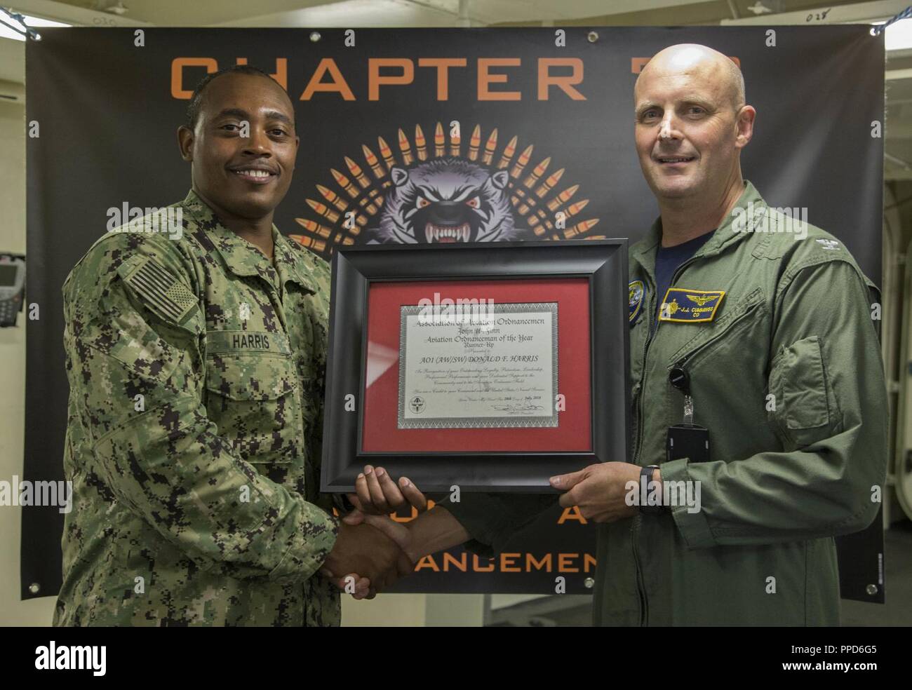 NEWPORT NEWS, Va. (Aug. 23, 2018) Aviation Ordnanceman 1st Class Donald Harris, from Tallahassee, Fla., assigned to USS Gerald R. Ford's (CVN 78) weapons department, left, is awarded Aviation Ordnanceman of the Year by Capt. John J. Cummings, Ford's commanding officer. Harris is will be promoted to chief petty officer next month. Stock Photo