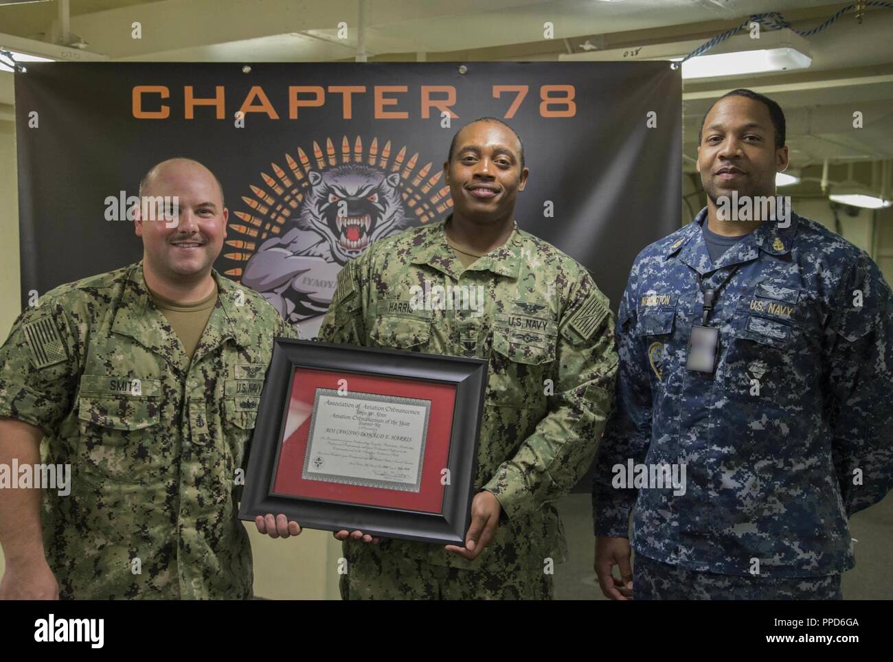 NEWPORT NEWS, Va. (Aug. 23, 2018) Aviation Ordnanceman 1st Class Donald Harris, from Tallahassee, Fla., assigned to USS Gerald R. Ford's (CVN 78) weapons department, center, poses for a group photo after being awarded Aviation Ordnanceman of the Year by Capt. John J. Cummings, Ford's commanding officer. Harris will be promoted to chief petty officer next month. Stock Photo